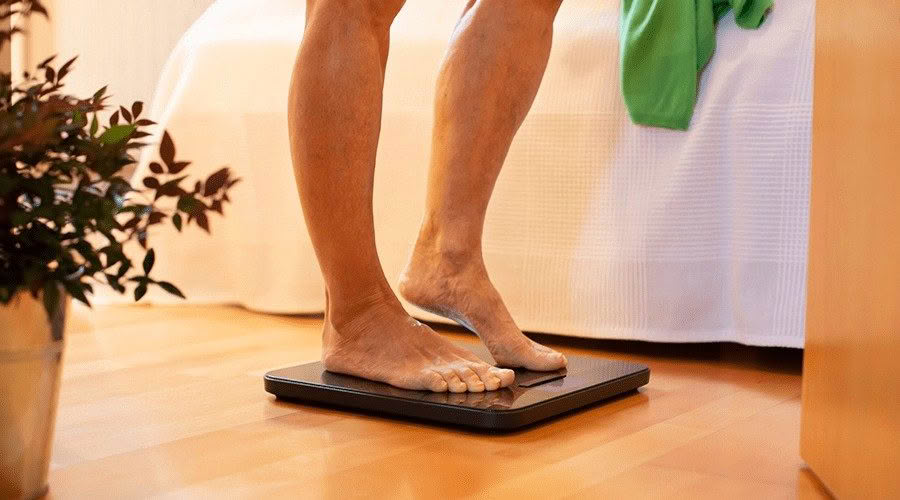 person weighing themselves on scales